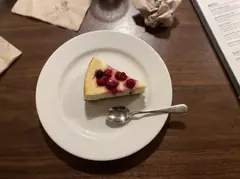 Tarta de queso tras la edición: luz lateral suave y madera oscura