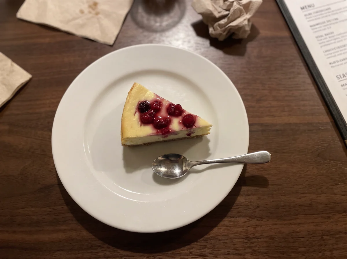 Tarta de queso con frutos rojos sobre madera oscura